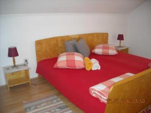 1 dormitorio con 1 cama roja grande y 2 almohadas en Casa Judith, en Turda
