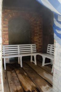 two white benches sitting next to a brick wall at Hotel Regina del Mare in Ischia
