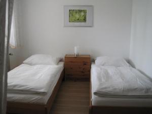 a bedroom with two beds and a dresser with a candle on it at Haus Meßmer in Bad Dürrheim