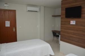 1 dormitorio con 1 cama y TV en la pared en Tapajos Palace Hotel, en Novo Progresso