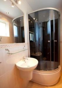 a bathroom with a white sink and a shower at Willa Apollo in Władysławowo +35 photos