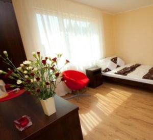 uma sala de estar com uma cama e um vaso de flores em Willa Apollo em Władysławowo