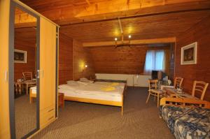 een slaapkamer met een bed in een houten kamer bij Penzión Pastierňa in Dedinky