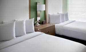 two beds with white pillows in a hotel room at Hayes Street Hotel Nashville in Nashville