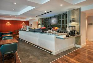 a restaurant with a counter and a bar at Hayes Street Hotel Nashville in Nashville