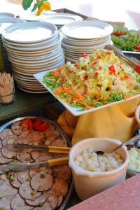 een buffet met gerechten met borden en kommen bij Village Vacances La Manne in Bormes-les-Mimosas
