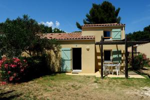 a small house with a table and chairs in a yard at Village Vacances La Manne in Bormes-les-Mimosas
