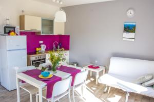 a kitchen with a white table and chairs in a room at Apartment Villa Franci in Pag