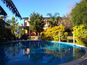 a large blue swimming pool in front of a house at Cabanas El Paramo in Colón