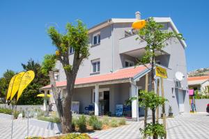 a white building with trees in front of it at Apartment Villa Franci in Pag