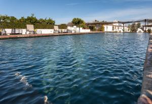 Una piscina de agua con algunas sillas. en Quinta Da Espada, en Évora