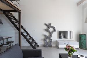 ein Wohnzimmer mit einer Treppe und einem TV in der Unterkunft La Suite de la Maison du Village in Gassin