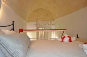 una cama con un animal de peluche sentado encima en Suite Al Ponte, en Taranto