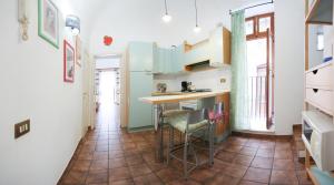 a kitchen with a table and chairs in a room at Caracciolo Lounge in Cefalù
