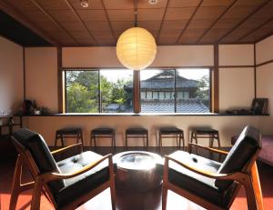 een kamer met een tafel en stoelen en een groot raam bij Kiraku Kyoto Higashiyama in Kyoto