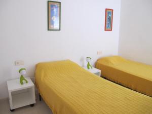 ラ・マンガ・デル・マール・メノールにあるSoling 5の小さな部屋のベッド2台 黄色いシーツ付