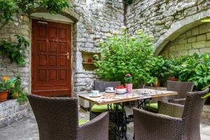 una mesa al aire libre con sillas y una puerta roja en Studio Terrace Borgoforte, en Trogir