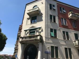 a white building with a balcony on the side of it at Cà Bèla - Lambrate Flat 2 in Milan