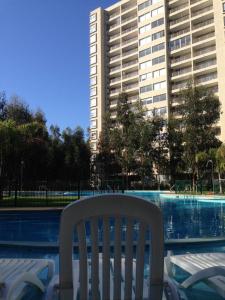 una silla blanca sentada frente a una piscina en Costa Algarrobo Norte, en Algarrobo