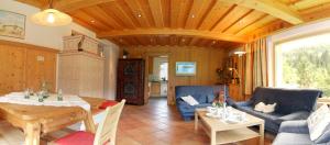 salon ze stołem i niebieską kanapą w obiekcie Haus Dachstein w mieście Filzmoos
