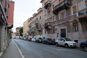 una fila de autos estacionados en una calle con edificios en Bonum Rooms en Split