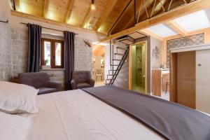 ein Schlafzimmer mit einem weißen Bett und zwei Stühlen in der Unterkunft Villa Kudelik - Stone Story in Trogir + 164 Fotos