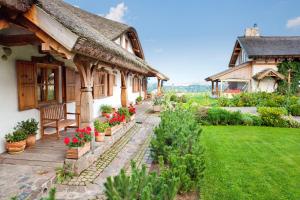 una casa con un banco y flores en un patio en Osada Głęboczek. Vine Resort&Spa en Wielki Głęboczek