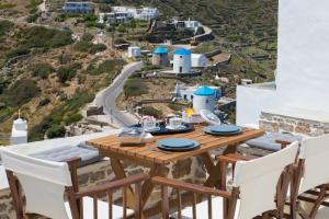 a table and chairs on a balcony with a view at Athina Exquisite Houses in Kastron