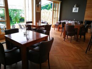 een eetkamer met houten tafels en stoelen bij Pensiune Restaurant La Cassa in Vişeu de Sus