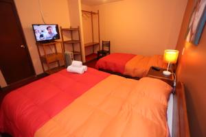 a bedroom with two beds and a tv in it at Totorani Inn in Puno +46 photos