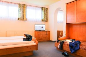 a bedroom with two beds and a television in it at Heli's B&B Frühstück "light" inkludiert in Saalbach-Hinterglemm