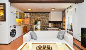 a living room with a white couch and a kitchen at Holiday Home Maris in Kotor