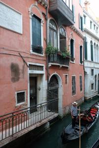 a man is standing in a gondola in a canal at The Palace 5613 in Venice