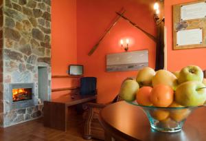 uma taça de fruta numa mesa numa sala com lareira em Apartamentos Rurales El Fresnu em Silvamayor