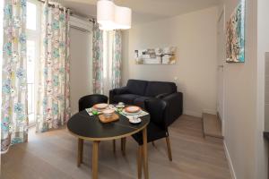 - un salon avec une table et un canapé dans l'établissement France-Nice-Carré d'Or (studio ou 2 pièces), à Nice