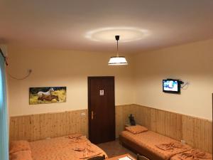 um quarto com duas camas e uma televisão na parede em Guroal Holiday House em Shëngjin