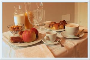 einen Tisch mit zwei Teller Essen und Tassen Kaffee in der Unterkunft Lanterna Room&Breakfast in Carpi