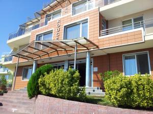 een gebouw met trappen en struiken ervoor bij Villa Rouge in Sozopol