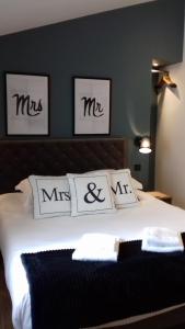 a bedroom with a bed with three pictures on the wall at Logis Hôtel La Chaize in Noirmoutier-en-l'lle
