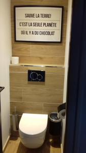 a bathroom with a toilet and a sign on the wall at Logis Hôtel La Chaize in Noirmoutier-en-l'lle
