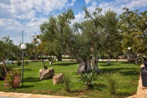 a park with trees and rocks in the grass at Tenuta Caradonna in Lequile