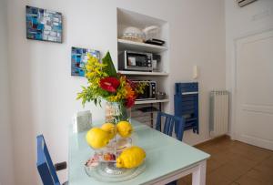 a table with a vase with flowers and lemons on it at boutique apartment al duomo in Salerno