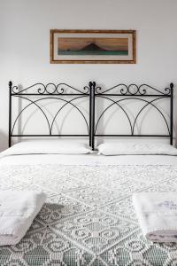 a bedroom with a bed with a black frame at Hotel Mercanti di Mare in Santa Marina Salina