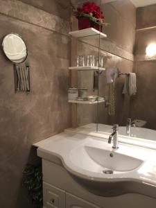 La salle de bains est pourvue d'un lavabo blanc et d'un miroir. dans l'établissement Hôtel Morris, à Le Pont-de-Beauvoisin