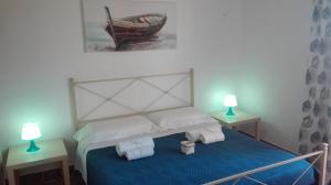 ポルトパーロにあるB&B Terra del Soleのベッドルーム1室(ベッド1台、ランプ2つ、テーブル2台付)