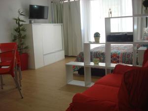 sala de estar con sofá rojo y TV en Rent Apart Caballito 2 en Buenos Aires