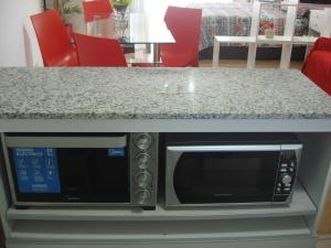 un horno de microondas sentado bajo una encimera de cocina en Rent Apart Caballito 2 en Buenos Aires