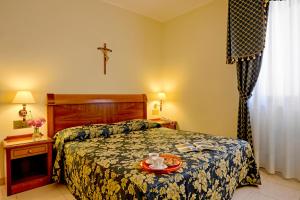 a bedroom with a bed with a tray of food on it at Hotel Centro di Spiritualità Padre Pio in San Giovanni Rotondo