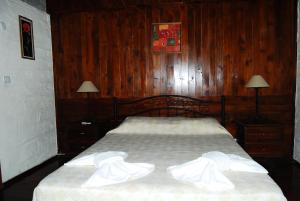 a bedroom with a bed with wood paneling and two lamps at Doga Apartments in Kayakoy