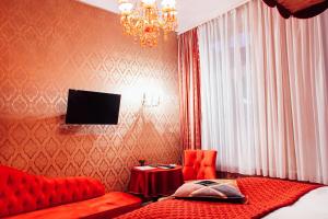 a bedroom with a red bed and a chandelier at Hotel Village in Hamburg